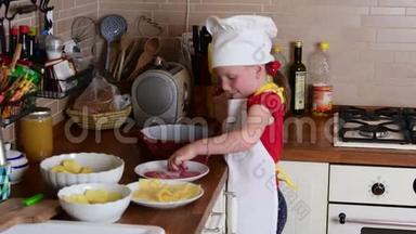 可爱的小女孩做晚餐。 小女孩在厨房准备食物。 可爱的小女孩打扮得像个厨师。